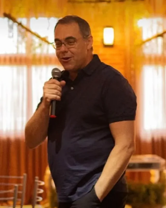 Miguel Rossato falando ao microfone em um evento